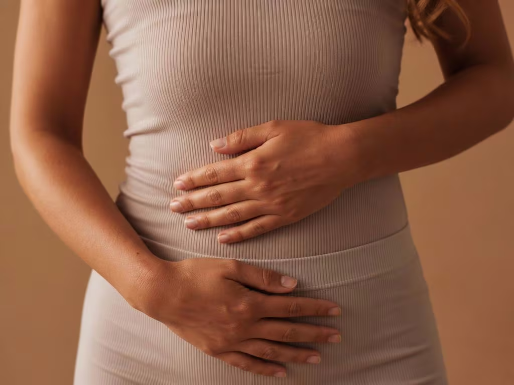 Mãos femininas repousando sobre o abdômen em top neutro — abdominoplastia